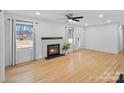 Bright living room features a fireplace, ceiling fan, and hardwood flooring at 6301 Vernedale Rd, Charlotte, NC 28212