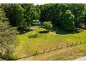Expansive backyard with a large grassy area, surrounded by lush trees and a rustic fence, offering privacy and tranquility at 6766 Little Mountain Rd, Sherrills Ford, NC 28673