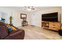 Inviting living room featuring a leather couch, ceiling fan, and a stylish console table with decorative accents at 712 Grace Ave, Kannapolis, NC 28083