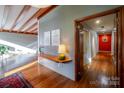 Inviting entryway with hardwood floors, wood beam ceiling, and wall accents that leads into a hallway at 714 Larkhall Ln, Charlotte, NC 28211
