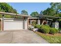 An exterior view showcasing a brick home with a garage and landscaped front yard with a concrete driveway at 714 Larkhall Ln, Charlotte, NC 28211