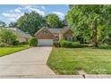 Charming brick home with a well-manicured lawn, mature trees, and a two-car attached garage at 752 Pinebough Ln, Rock Hill, SC 29732