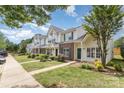 View of townhomes with green shutters and landscaping, creating a welcoming neighborhood street at 7718 Petrea Ln, Charlotte, NC 28227