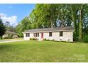 Inviting single-story home with a lush green lawn and mature trees, offering great curb appeal at 808 Sharon Dr, Waxhaw, NC 28173