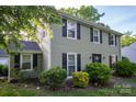 Well-maintained home with black shutters, complemented by landscaped bushes and lawn at 9801 Kent Village Dr, Charlotte, NC 28269
