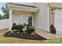 Charming front entrance featuring a beautifully landscaped flower bed and seating at 104 Trellis Ln, Troutman, NC 28166