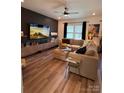 Cozy living room featuring a sectional sofa, a decorative fireplace, and sleek hardwood floors at 104 Trellis Ln, Troutman, NC 28166