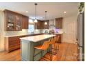 Well-equipped kitchen with an island, quartz countertops, stainless steel appliances, and hardwood floors at 10501 Stonemede Ln, Matthews, NC 28105