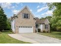 Side view of a charming brick and siding home with a two-car garage at 14807 Middlesborough Dr, Matthews, NC 28104