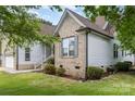 Side view of a charming brick and siding home with manicured landscaping at 14807 Middlesborough Dr, Matthews, NC 28104