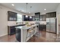 Modern kitchen featuring black cabinets, stainless steel appliances, granite countertops, and a large island at 1507 Arcadia Bluff Dr, York, SC 29745