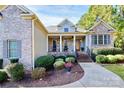 Inviting brick home featuring covered front porch and meticulous landscaping in desirable neighborhood at 162 Kenway Loop, Mooresville, NC 28117