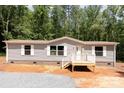 Charming home featuring gray siding, white trim, and a cozy front porch nestled in a wooded setting at 1785 Doe Ct, Iron Station, NC 28080