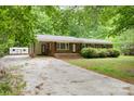 Well-maintained brick home with a long driveway and charming curb appeal surrounded by greenery at 1874 Sunny Ln, Lancaster, SC 29720