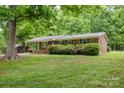 Beautiful brick home with lush green lawn and mature trees providing shade and curb appeal at 1874 Sunny Ln, Lancaster, SC 29720