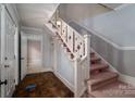 View of the foyer and staircase that features decorative railings and an overhead light fixture at 2240 Armstrong Park Dr, Gastonia, NC 28054