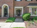 Charming brick home with an inviting front entrance featuring decorative door and manicured landscaping at 232 Perrin Pl, Charlotte, NC 28207