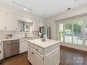 Bright kitchen featuring white cabinets, a center island, stainless steel appliances and natural light at 232 Perrin Pl, Charlotte, NC 28207