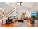 Cozy living room with hardwood floors, vaulted ceilings, ceiling fan, and staircase leading to second floor at 3032 Kilbeggan Dr, Lake Wylie, SC 29710