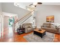 Bright living room with hardwood floors, vaulted ceilings, staircase, and comfortable seating arrangement at 3032 Kilbeggan Dr, Lake Wylie, SC 29710