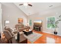 Inviting living room with hardwood floors, vaulted ceilings, comfortable seating, and modern entertainment center at 3032 Kilbeggan Dr, Lake Wylie, SC 29710
