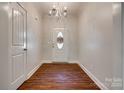 Bright entryway featuring hardwood floors, chandelier, and decorative front door at 3243 Farmcrest Ct, Fort Mill, SC 29708