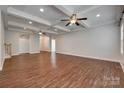 Open living room with hardwood flooring, coffered ceiling, and a view of the entryway at 3243 Farmcrest Ct, Fort Mill, SC 29708