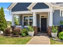Inviting front porch with brick accents, white columns, and stylish plants, offering a warm welcome at 3588 County Down Ave, Kannapolis, NC 28081