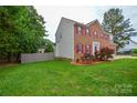 Well-maintained brick home with red shutters, an attached garage, and green lawn at 3602 Brookstone Trl, Indian Trail, NC 28079