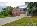 Traditional brick home boasts a spacious driveway, two-car garage, and manicured lawn at 3602 Brookstone Trl, Indian Trail, NC 28079