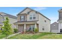 Attractive two-story home features brick accents, a covered front porch, and a green lawn at 363 Cedar Knoll Cir, Pineville, NC 28134