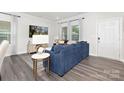 Inviting living room with a blue sectional sofa, decorative rug, and bright natural light at 363 Cedar Knoll Cir, Pineville, NC 28134