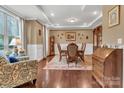 Elegant dining room with hardwood floors, tray ceiling, wainscotting, and classic furnishings at 4071 Thames Cir, Fort Mill, SC 29715