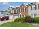 Charming brick townhome with a one car garage, well manicured lawn, and sunny skies at 4208 Carl Parmer Dr, Harrisburg, NC 28075