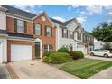 Brick townhome with a one car garage, well manicured lawn and driveway at 4208 Carl Parmer Dr, Harrisburg, NC 28075