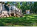 View of the backyard, featuring a wooden shed and lush greenery, accessible by steps from the back porch at 4920 Morrison Houser Trl # 2, Lincolnton, NC 28092