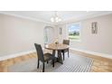 Cozy dining area with modern table, chairs and a view to the outdoors at 6012 Tuckaseegee Rd, Charlotte, NC 28208