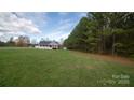 A view of the beautiful, grassy, spacious front yard with trees surrounding the property at 6300 Bill Sain Rd, Vale, NC 28168