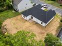 An aerial view shows a spacious backyard and a newly constructed home with a dark roof at 722 English St, Monroe, NC 28110