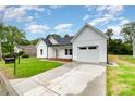 A charming home features a well-manicured lawn and an attached garage, showcasing curb appeal at 722 English St, Monroe, NC 28110