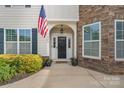 Inviting front entrance with an American flag, beautiful stone accents, and well-maintained landscaping at 7405 Albemarle Dr, Denver, NC 28037
