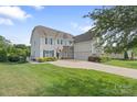 Beautifully landscaped home with lush green lawn and mature trees enhancing its inviting curb appeal and traditional charm at 7405 Albemarle Dr, Denver, NC 28037