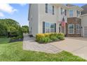 Charming walkway leads to the home's entrance, complemented by manicured landscaping and verdant lawn at 7405 Albemarle Dr, Denver, NC 28037