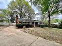 Brick home with a long driveway and a well-manicured lawn at 8205 Meadowind Cir, Charlotte, NC 28226