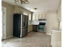 Bright kitchen with stainless steel appliances, white cabinets, and tile flooring at 8205 Meadowind Cir, Charlotte, NC 28226