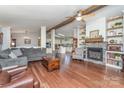 Open living room featuring hardwood floors, stone fireplace, wood beams, and a view to the kitchen at 940 Hatchett Rd, Lincolnton, NC 28092