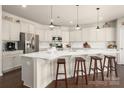 Bright kitchen features white cabinetry, stainless steel appliances, subway tile backsplash, and a large center island with bar seating at 9613 Fire Bellied Ct, Lancaster, SC 29720