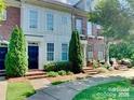 Beautiful townhome with a brick facade, complemented by lush greenery and inviting walkways at 9832 Longstone Ln, Charlotte, NC 28277