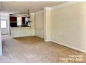 Bright living room with neutral walls and an open layout leading to the kitchen at 9832 Longstone Ln, Charlotte, NC 28277