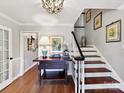 Classic foyer with hardwood floors, staircase with white railing, and stylish decor at 10024 Whitethorn Dr, Charlotte, NC 28277